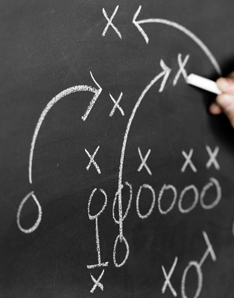 Chalkboard marked up to demonstrate a football play.